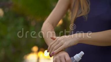 一位美丽的年轻女子用<strong>防蚊</strong>剂喷在皮肤上的超慢镜头。 一片热带